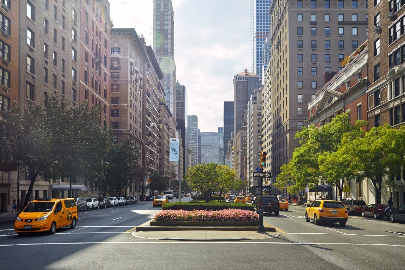 Yellow taxis and historic buildings along a New York City street.