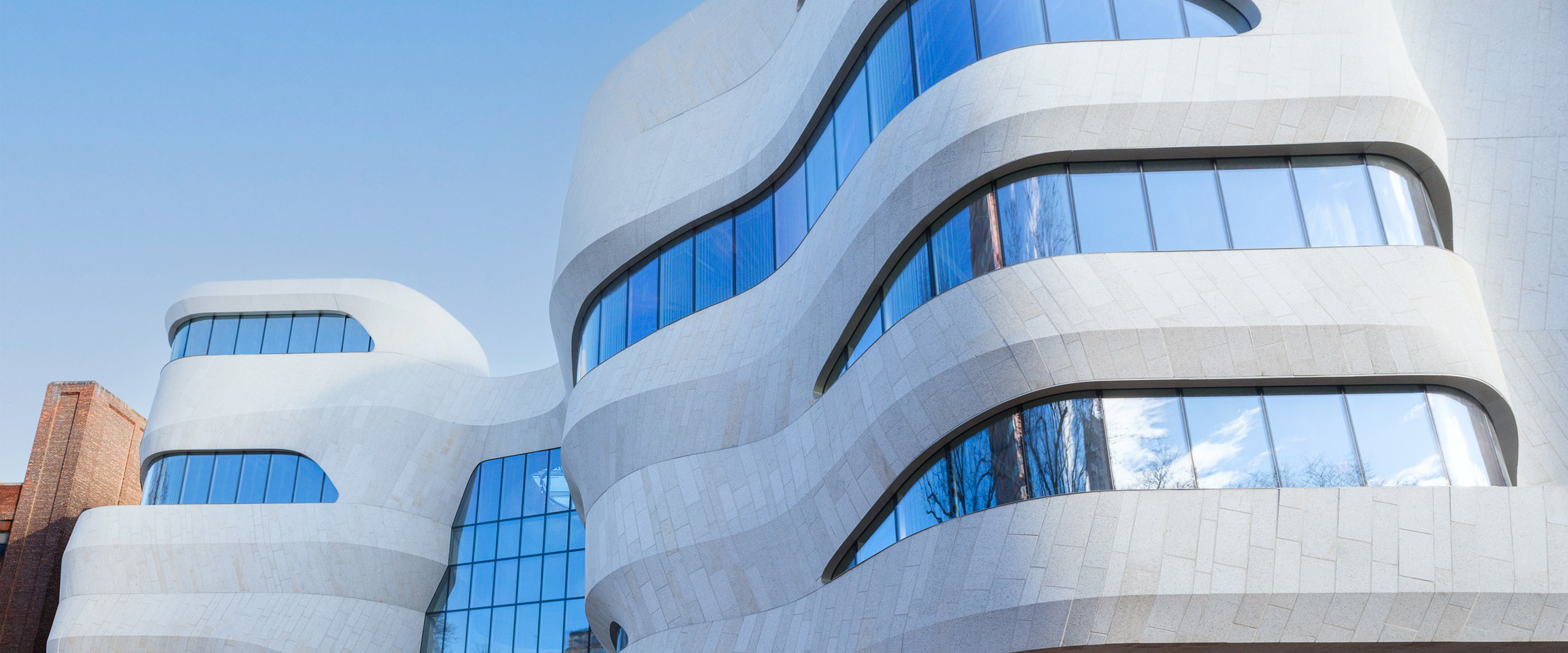 Modern white and blue glass building with curved architecture.