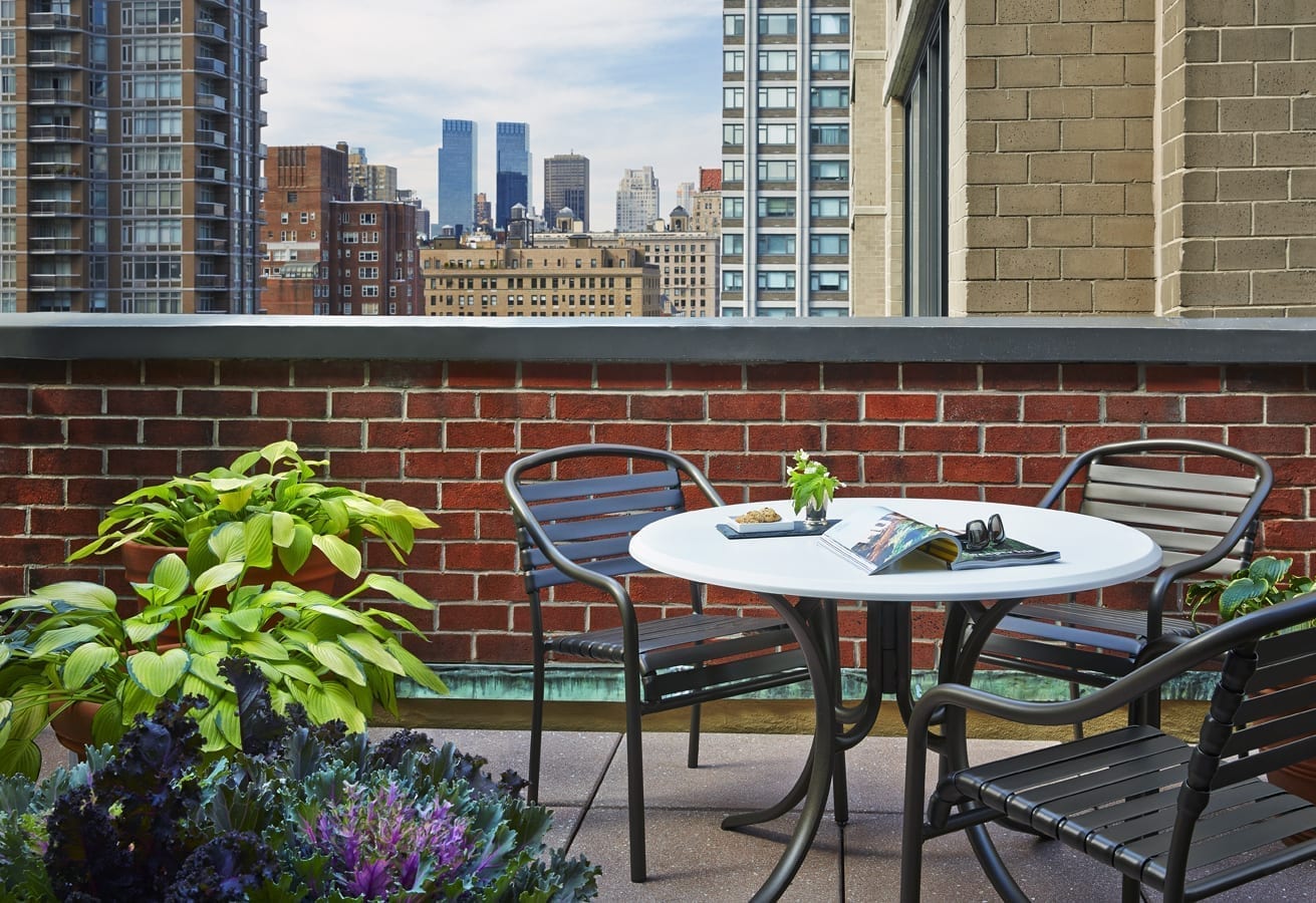 Cozy outdoor terrace with table and city skyline view.