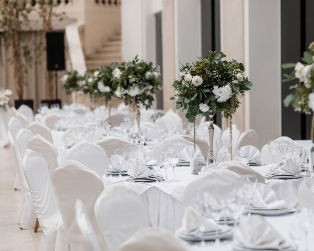 Grand wedding reception hall with white floral decor.