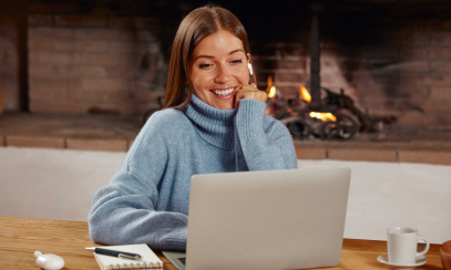 Woman sitting down and looking at her laptop.