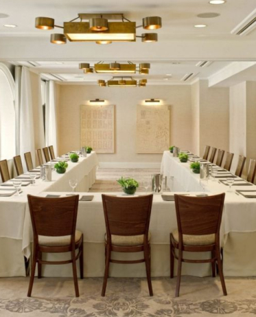 Hotel event space with a U shaped table and wooden chairs.