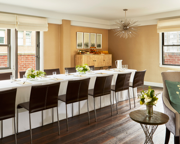 Bright dining area with modern table and fresh flowers.