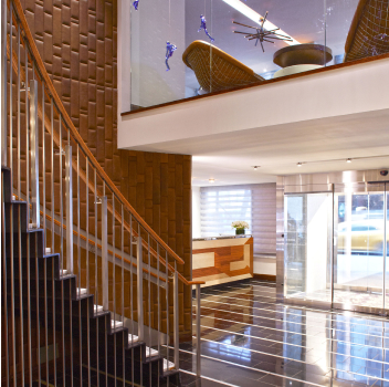 Hotel lobby with sleek staircase and warm lighting.