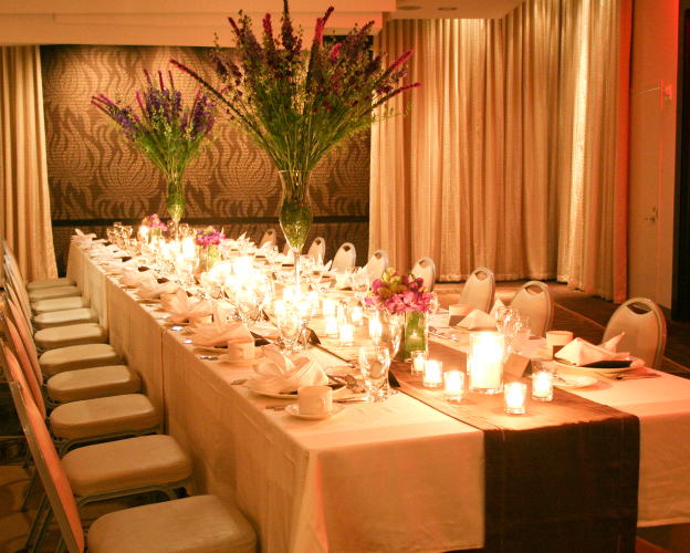 Romantic banquet table with candlelit floral decorations.