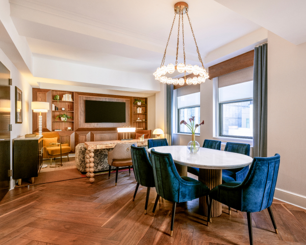 Luxury suite with dining table, chandelier, and lounge area.