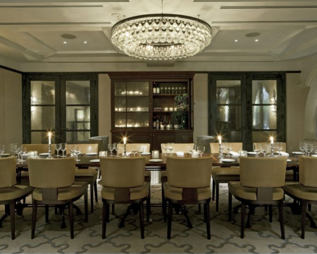 Private dining room with chandelier and candlelit table.