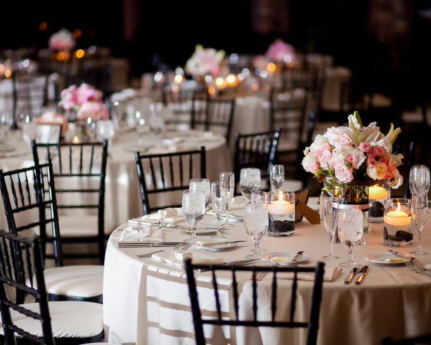 Elegant event setup with round tables and candlelit decor.