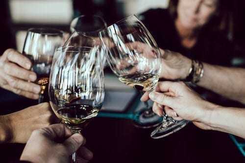 Close-up of wine glasses clinking in a toast.