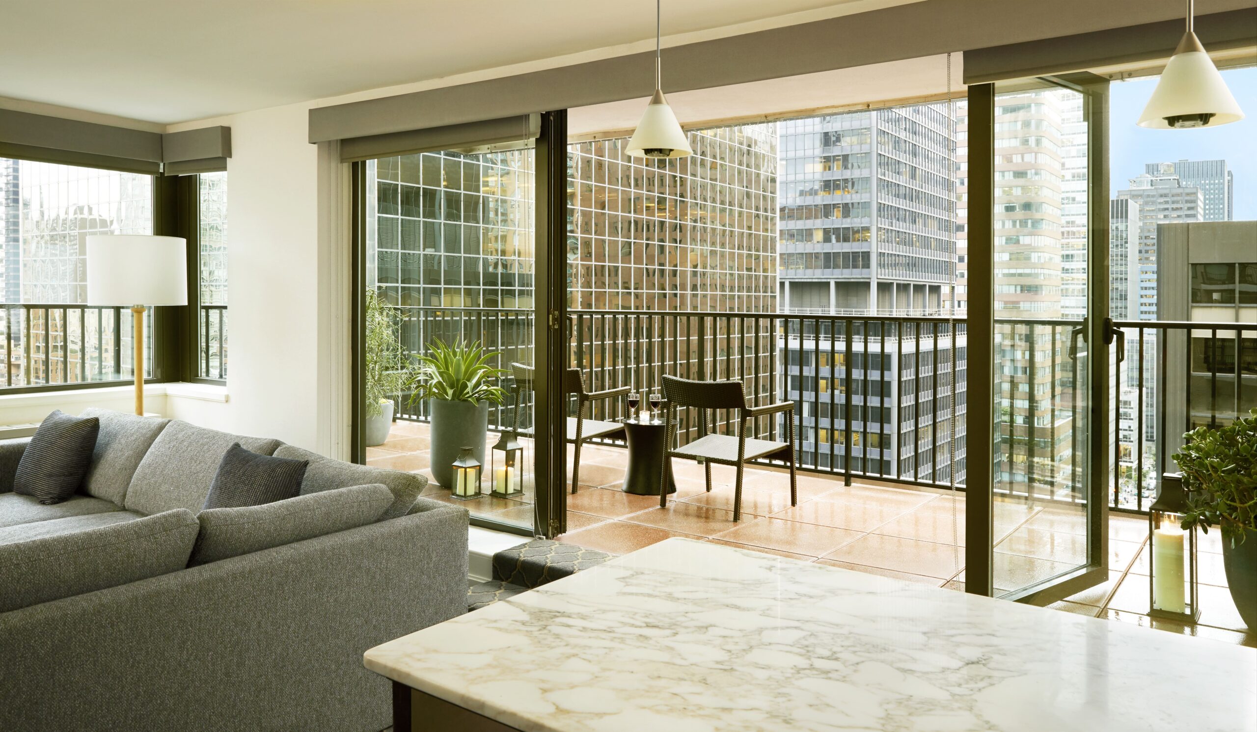 Spacious hotel suite with floor-to-ceiling windows.