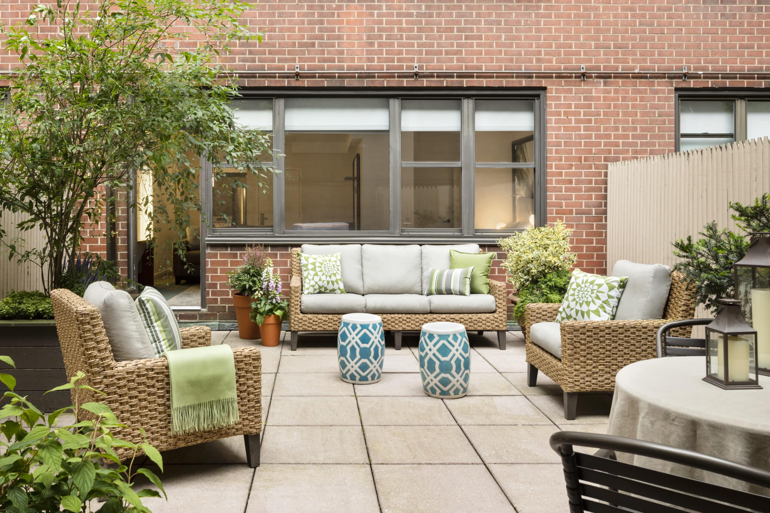 Charming patio with cushioned seating and greenery.