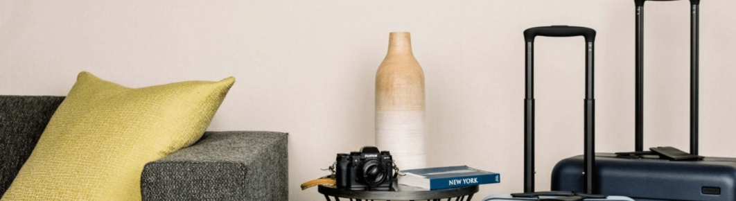 Cozy seating area with luggage, book, and camera.