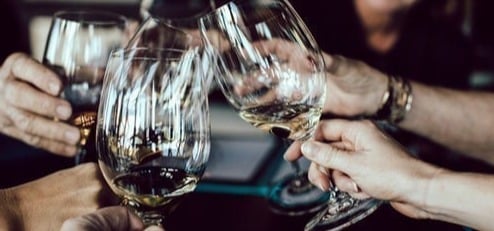 Close-up of wine glasses clinking in a toast.