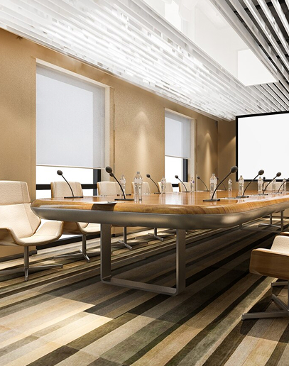 Modern conference room with large table and microphones.