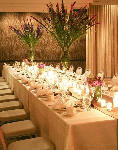 Elegant banquet table with floral centerpieces and candles.