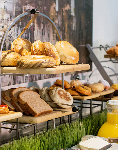 Breakfast buffet with fresh bagels, bread, and juice.