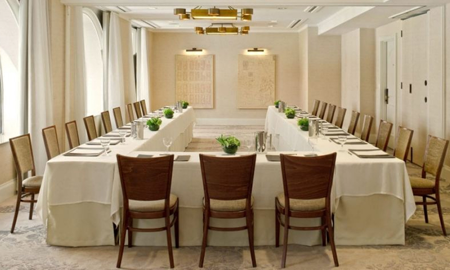 Elegant conference room with large U-shaped table setup.