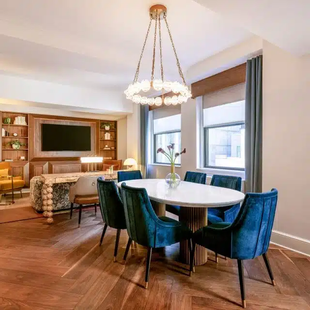 Room with centralized table and chair, and mounted tv on the wall.